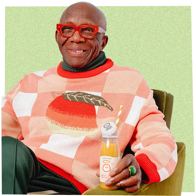 man sat drinking an innocent smoothie wearing a big knitwear jumper